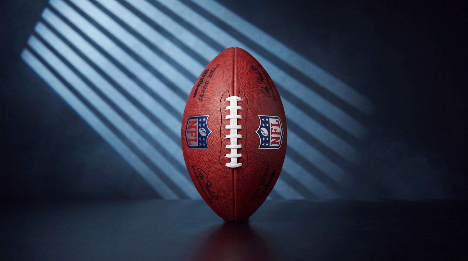 Wilson The Duke NFL football standing upright in cold blue striped studio light, cover for the guide to buying American football equipment in Europe